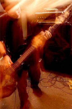 Blurry atmospheric abstract noisy hazy image of a bass player rippin' thru songs. Shot with slow shutter speed and flash for lots of movement and effect. Fotografie stock - Microstock e Abbonamento, Codice: 400-03940872