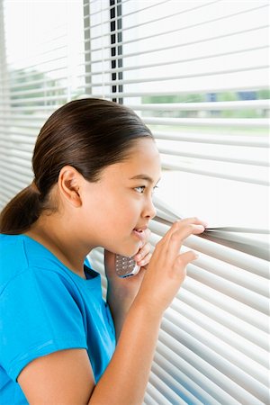 peeking store window - Side view of Asian preteen girl looking through blinds out window. Photographie de stock - Aubaine LD & Abonnement, Code: 400-03940880