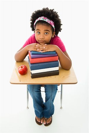 simsearch:400-03923096,k - African American girl sitting at school desk with large stack of books looking up at viewer. Stock Photo - Budget Royalty-Free & Subscription, Code: 400-03940958