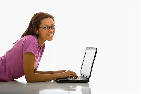 simsearch:400-03926822,k - Side view of mid adult African American woman lying on floor using laptop smiling at viewer. Stock Photo - Budget Royalty-Free & Subscription, Code: 400-03940951