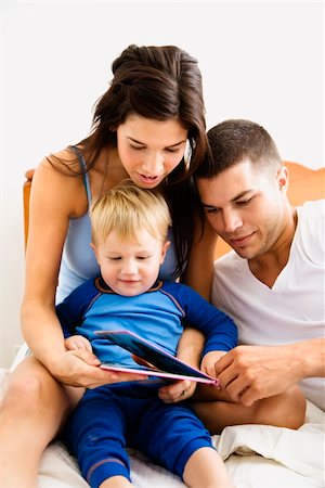 Caucasian parents and toddler son reading book in bed. Stock Photo - Budget Royalty-Free & Subscription, Code: 400-03941017