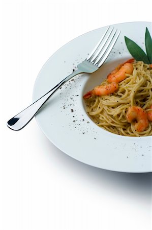 Spaghetti and prawns in a cream sauce, garnished with herbs. Served on a deep white, round bowl with wide rim sprinkled with ground pepper. Includes clipping path to change background and isolate from shadow. Stockbilder - Microstock & Abonnement, Bildnummer: 400-03941250