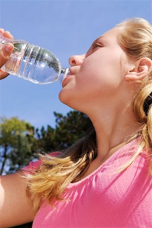 Young girl drinking water out of a plastic bottle outside Photographie de stock - Aubaine LD & Abonnement, Code: 400-03941398