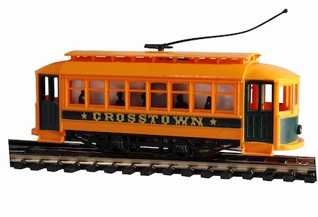 This bright yellow plastic HO gauge toy trolley is headed crosstown. The trolley pole is raised. You can see the silhouettes of happy passengers inside waiting for their ride to begin. Photographie de stock - Aubaine LD & Abonnement, Code: 400-03942060
