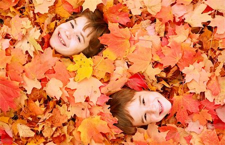 simsearch:400-05875962,k - Deux petits garçons visages enterrés dans les feuilles d'automne coloré Photographie de stock - Aubaine LD & Abonnement, Code: 400-03942126