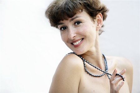 Happy mature topless woman playing with a pearl necklace Photographie de stock - Aubaine LD & Abonnement, Code: 400-03942746