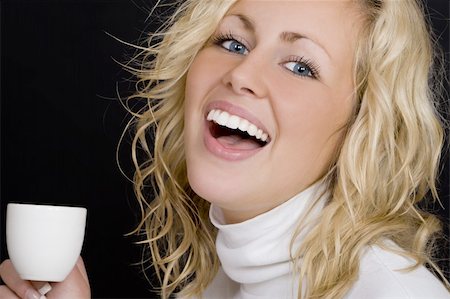 simsearch:400-03920671,k - Studio shot on a black background beautiful young blond woman wearing white, laughing and drinking coffee. Stock Photo - Budget Royalty-Free & Subscription, Code: 400-03942798