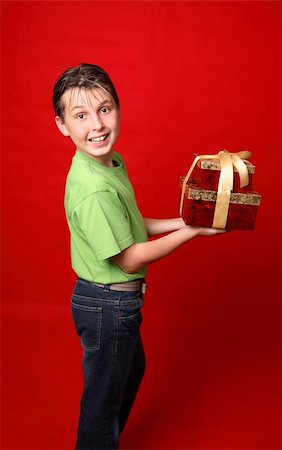 simsearch:400-03961239,k - A smiling boy in casual clothes carrying gifts tied with ribbon Photographie de stock - Aubaine LD & Abonnement, Code: 400-03942889