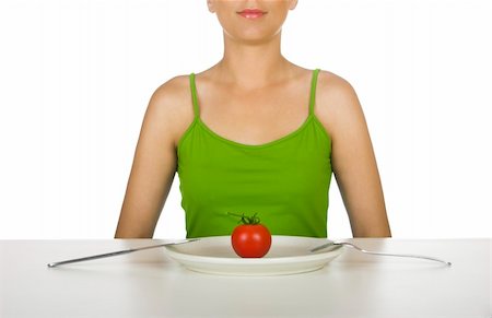 simsearch:400-05741507,k - Woman in the kitchen with a tomato on the plate in front of her Stockbilder - Microstock & Abonnement, Bildnummer: 400-03942957