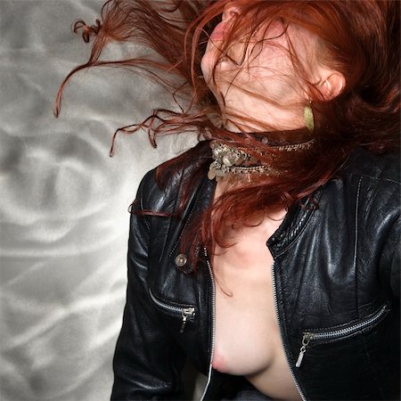 simsearch:6113-06497995,k - Partially nude Caucasian woman in leather jacket flipping long hair in air. Stock Photo - Budget Royalty-Free & Subscription, Code: 400-03943324