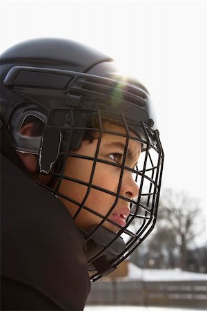 simsearch:858-07653571,k - Close up of ice hockey player boy in cage helmet with look of concentration. Foto de stock - Royalty-Free Super Valor e Assinatura, Número: 400-03943515