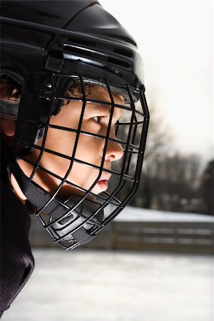 Ice hockey player boy in uniform and cage helmet concentrating. Photographie de stock - Aubaine LD & Abonnement, Code: 400-03943520