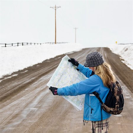 Young woman in winter clothes standing on muddy dirt road looking at map. Stock Photo - Budget Royalty-Free & Subscription, Code: 400-03943534