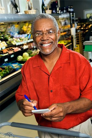 simsearch:400-03926822,k - Middle aged African American man in grocery store holding shopping list and smiling at viewer. Stock Photo - Budget Royalty-Free & Subscription, Code: 400-03943969