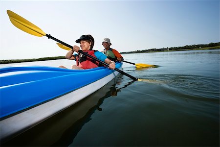 Low angle of African American middle-aged man and woman paddling kayak. Stock Photo - Budget Royalty-Free & Subscription, Code: 400-03943976