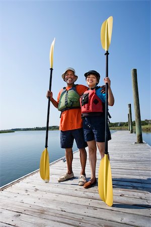 simsearch:400-03943979,k - African American middle-aged couple standing on boat dock holding paddles and smiling at viewer. Foto de stock - Super Valor sin royalties y Suscripción, Código: 400-03943978