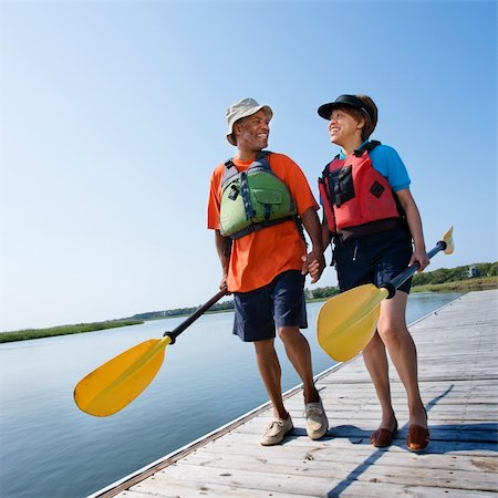simsearch:400-03943979,k - African American middle-aged couple walking on boat dock holding hands and carrying paddles. Foto de stock - Super Valor sin royalties y Suscripción, Código: 400-03943979