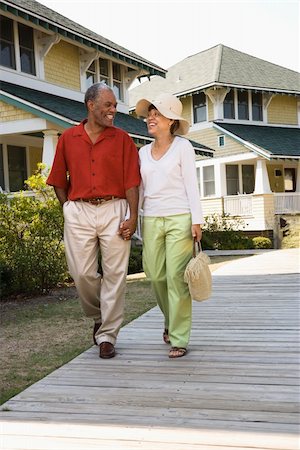 simsearch:400-03943979,k - African American middle aged couple holding hands strolling on wooden walkway. Foto de stock - Super Valor sin royalties y Suscripción, Código: 400-03943971
