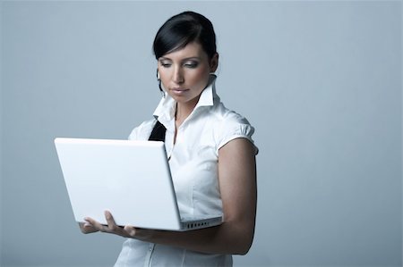 simsearch:400-03954172,k - Beautiful and sexy brunette business woman with laptop computer. She is isolated on clear background Stock Photo - Budget Royalty-Free & Subscription, Code: 400-03954166