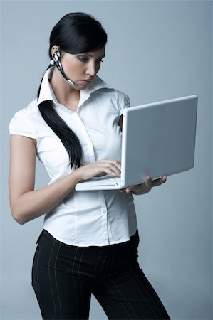 simsearch:400-03954172,k - Beautiful brunette business woman with wireless headset and laptop computer isolated on clear background Stock Photo - Budget Royalty-Free & Subscription, Code: 400-03954162