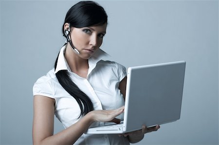 simsearch:400-03954172,k - Beautiful brunette business woman with wireless headset and laptop computer isolated on clear background Stock Photo - Budget Royalty-Free & Subscription, Code: 400-03954163