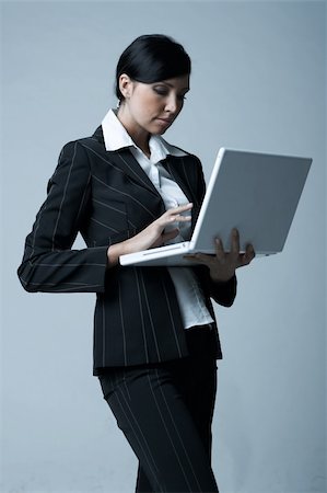 simsearch:400-03954172,k - Beautiful and sexy brunette business woman with laptop computer. She is isolated on clear background Stock Photo - Budget Royalty-Free & Subscription, Code: 400-03954172