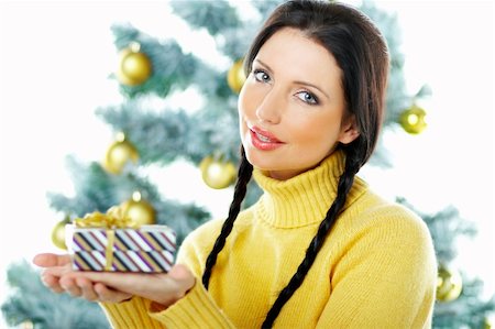 simsearch:700-02461235,k - Beautiful brunette woman next to christmas tree on white background holding boxed gift Fotografie stock - Microstock e Abbonamento, Codice: 400-03954182
