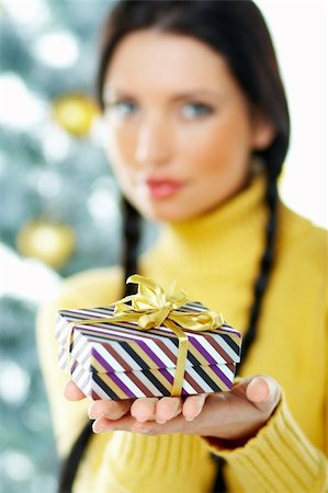 simsearch:700-02461235,k - Beautiful brunette woman next to christmas tree on white background holding boxed gift Fotografie stock - Microstock e Abbonamento, Codice: 400-03954190