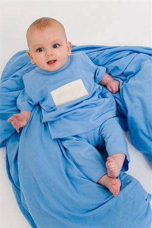 simsearch:400-04984240,k - A young male baby dresssed in blue pyjamas laying back and relaxing on blue bedclothes Stock Photo - Budget Royalty-Free & Subscription, Code: 400-03955680