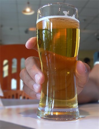 simsearch:841-03063177,k - A man's hand holding a light beer glass in a cafee Photographie de stock - Aubaine LD & Abonnement, Code: 400-03955808