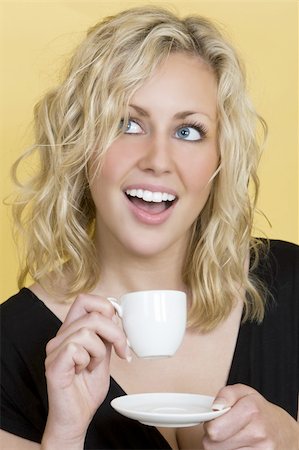 portrait photo of people socialising in a cafe - Studio shot of a beautiful young blonde woman drinking tea/coffee and laughing Stock Photo - Budget Royalty-Free & Subscription, Code: 400-03956042