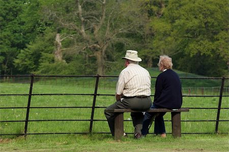 simsearch:400-05340916,k - Elderly couple sitting together on a bench in front of a fence, gazing at a rural view . Foto de stock - Super Valor sin royalties y Suscripción, Código: 400-03957958