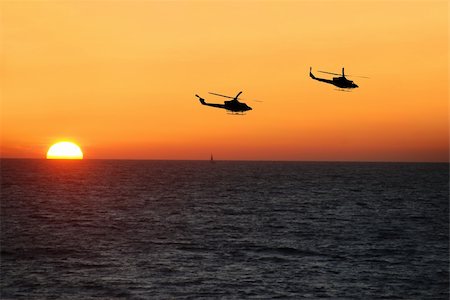 Choppers flying over the ocean at sunset Photographie de stock - Aubaine LD & Abonnement, Code: 400-03950094