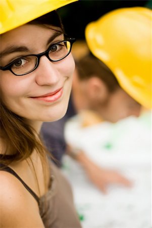 simsearch:400-05876095,k - young female smiling architect or builder wearing a yellow hart hat on a construction site Stock Photo - Budget Royalty-Free & Subscription, Code: 400-03950141