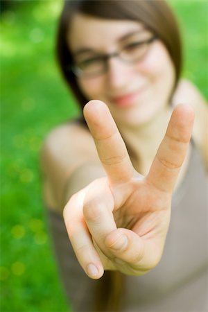 young smiling woman making victory gesture Stock Photo - Budget Royalty-Free & Subscription, Code: 400-03950166