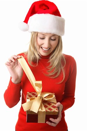 simsearch:649-06812641,k - A happy girl in anticipation,  pulls open the golden ribbon bow from a Christmas present Stock Photo - Budget Royalty-Free & Subscription, Code: 400-03950530