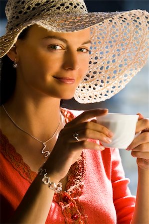 simsearch:400-03920671,k - A beautiful young brunette woman drinking a cup of tea or coffee lit buy beautifully golden and soft natural light Stock Photo - Budget Royalty-Free & Subscription, Code: 400-03950826