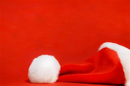 simsearch:400-04657079,k - Red santa hat against a red background Fotografie stock - Microstock e Abbonamento, Codice: 400-03951627