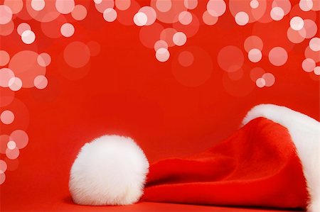 simsearch:400-04657079,k - Red santa hat against a red background Fotografie stock - Microstock e Abbonamento, Codice: 400-03951628