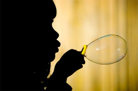 Silhuette of a little girl making a big bubble against yellow background. Stock Photo - Budget Royalty-Free & Subscription, Code: 400-03951739