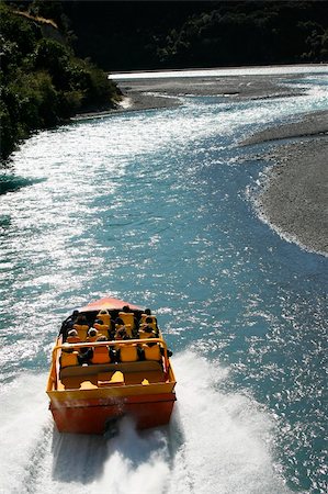 A jet boat driving up the Waimakariri River in New Zealand shot from a helicopter. Fotografie stock - Microstock e Abbonamento, Codice: 400-03951795