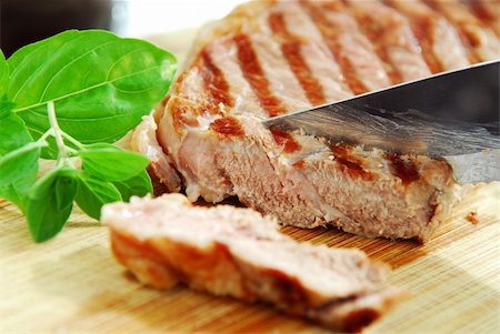 simsearch:6118-08660061,k - Grilled steak being cut on a cutting board, closeup Photographie de stock - Aubaine LD & Abonnement, Code: 400-03952521