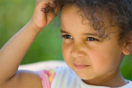 A beautiful mixed race girl backlit by summer sunshine, scratching her head and thinking Stock Photo - Budget Royalty-Free & Subscription, Code: 400-03952559