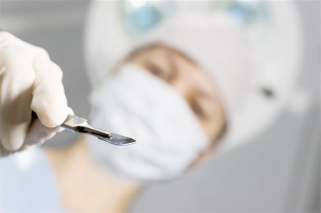 simsearch:400-05060422,k - Perspective of a patient on a operating table who sees the doctor above him with a scalpel in his hand. Focus only on the scalpel. Stock Photo - Budget Royalty-Free & Subscription, Code: 400-03952562