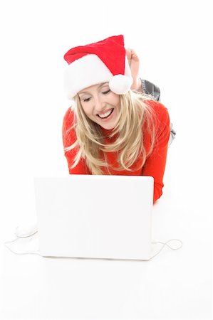 simsearch:600-02756462,k - Christmas girl using a laptop to shop or browse the web online. She might also be studying chatting to friends or family  or electronic banking, etc.    She is wearing a festive santa hat and smiling. Photographie de stock - Aubaine LD & Abonnement, Code: 400-03952760