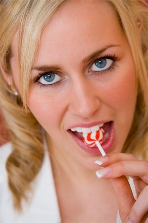 simsearch:649-03292817,k - A stunningly beautiful blue eyed blonde haired young woman sucking on a lollipop Stock Photo - Budget Royalty-Free & Subscription, Code: 400-03953157