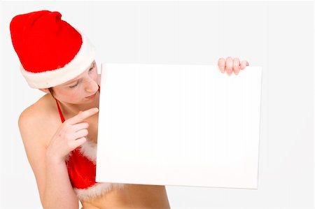 simsearch:693-07444529,k - Beautifull girl in christmas bikini and with christmas hat is holding up a white sign for copy space. With background clipping path for your convenience Stock Photo - Budget Royalty-Free & Subscription, Code: 400-03964547