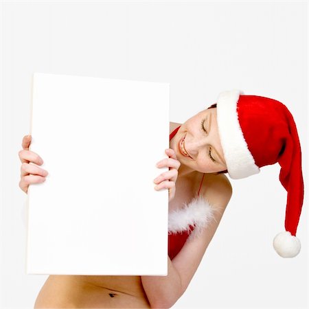 simsearch:693-07444529,k - Beautifull girl in christmas bikini and with christmas hat is hlding up a white sign for copy space. With background clipping path for your convenience Stock Photo - Budget Royalty-Free & Subscription, Code: 400-03964549