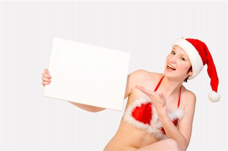 simsearch:693-07444529,k - Beautifull girl in christmas bikini and with christmas hat is hlding up a white sign for copy space. With background clipping path for your convenience Stock Photo - Budget Royalty-Free & Subscription, Code: 400-03964696
