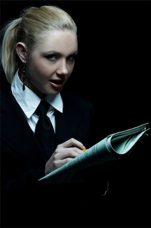 Beautiful business woman wearing black tie and jacket isolated on black background holding newspaper Stock Photo - Budget Royalty-Free & Subscription, Code: 400-03964957